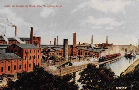 The John A. Roebling wire rope works moved to Trenton in 1848, and by 1903 the plant employed 5,000 workers and covered 35 acres of the capital city.  The Roebling works was situated on a site which took advantage of both the Delaware and Raritan Canal and the Camden and Amboy Railroad.  This image shows a passenger train of the Camden and Amboy passing two canal steamboats near the Roebling works.  The impact of Roebling’s development of wire rope and its application to civil engineering can scarcely be overstated.  Roebling’s wire rope was used for the aqueducts of the Delaware and Hudson Canal, the inclined planes of the Morris Canal, as well many suspension bridges throughout the United States.  So significant was Roebling’s Trenton complex, it is thought to have inspired the motto on the Lower Trenton Bridge: “Trenton Makes, the World Takes.”